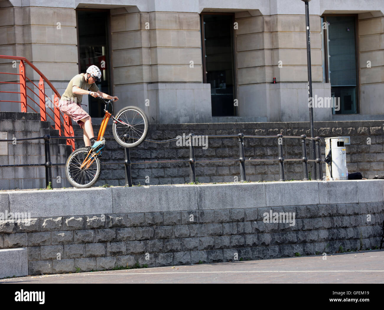 Jeune homme jouant sur son vélo stunt à l'extérieur le bâtiment de la Lloyds à Londres près du port. 31 Juillet 2016 Banque D'Images