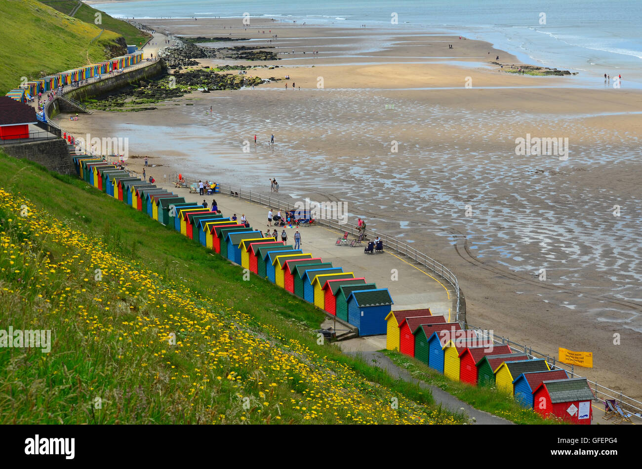 Cabines de plage multicolores à Whitby, Plage, Whitby, Yorkshire, Angleterre, Royaume-Uni. Sandsend dans la distance Banque D'Images