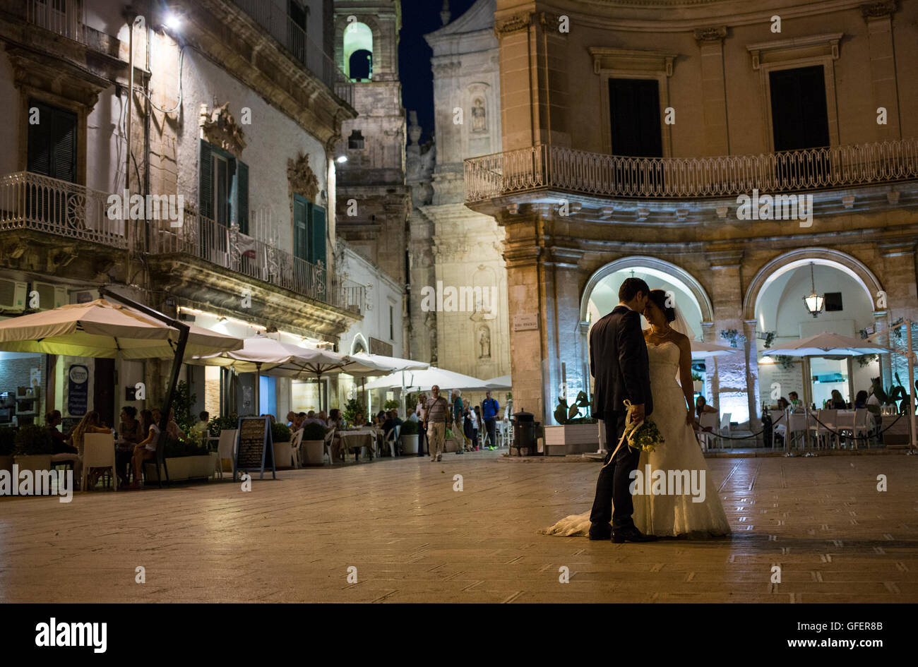 Une femme et un homme poser pour un photographe à Piazza Plebiscito en Martina Franca, Pouilles, Italie Banque D'Images