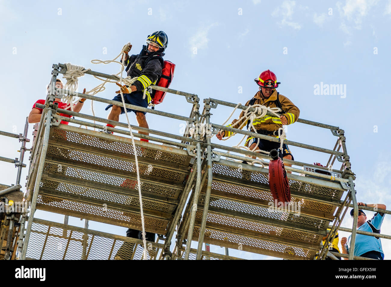 Belfast, Irlande du Nord. 8 Août 2013 - Deux pompiers tirer plus de 100ft sur tuyaux d'un bras à l'ultime manifestation des pompiers, de la police et des pompiers du monde jeux (WPFG) Banque D'Images