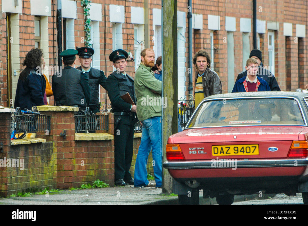 Belfast, Irlande du Nord. 18 déc 2014 - Acteurs habillés comme des Royal Ulster Constabulary (RUC) d'officiers républicains irlandais et se tenir sur une rue à Belfast au cours d'un tournage vidéo film. Banque D'Images