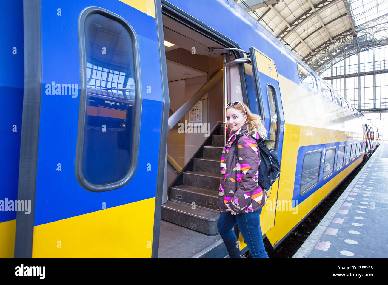 Jeune femme prenant le train à la gare centrale d'Amsterdam aux Pays-Bas Banque D'Images