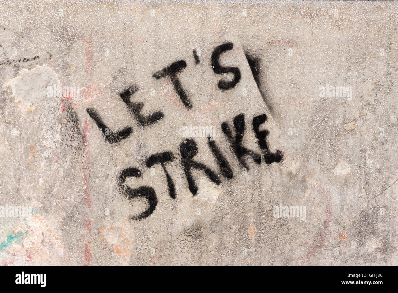 Graffiti peint en aérosol noir sur un mur à Venise, 'let's Strike'. Concept: Protestation, protestation, action industrielle Banque D'Images