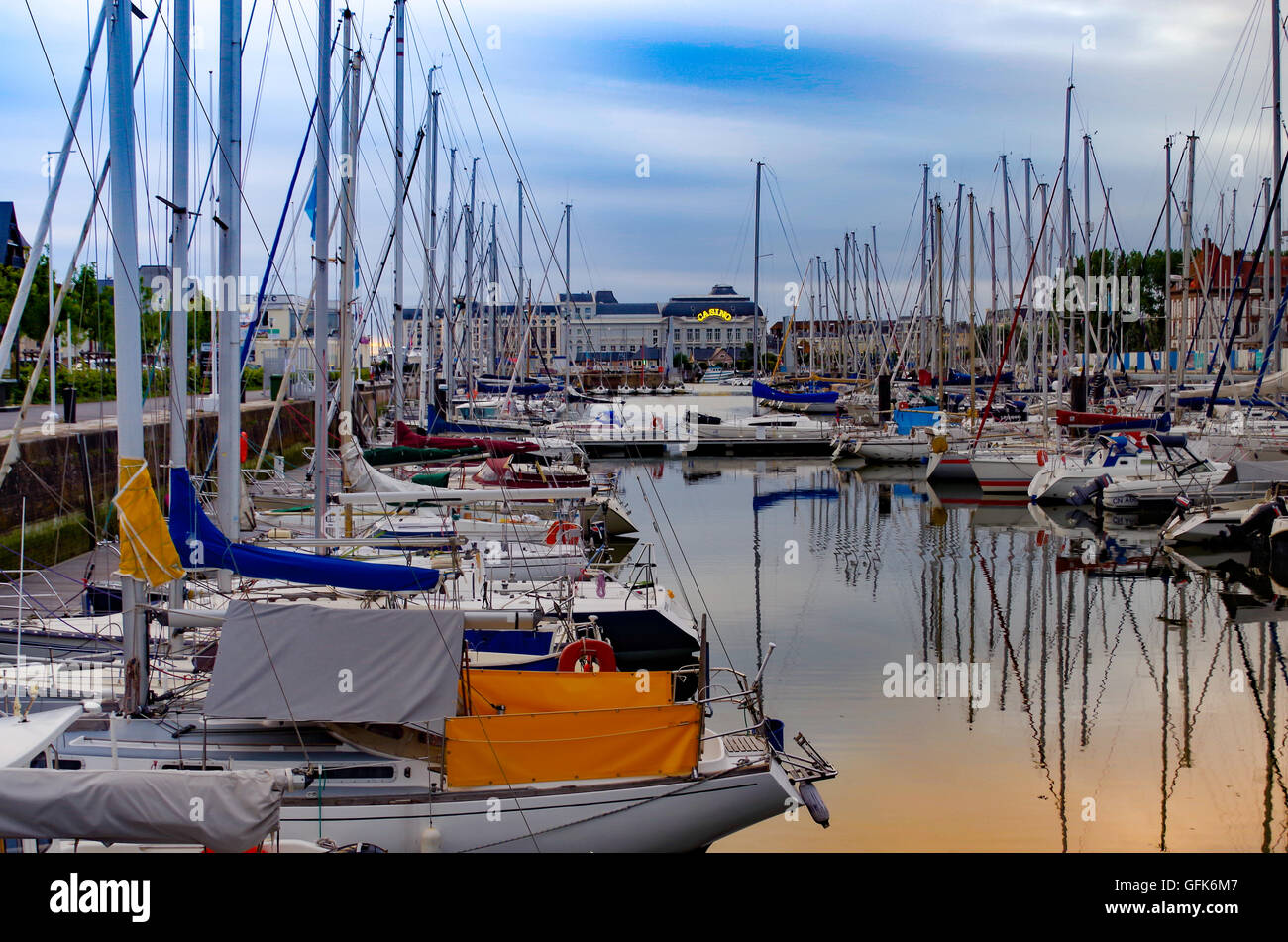 Port de plaisance de Deauville-sur-Mer en France à la tombée d'un célèbre casino de Trouville-sur-Mer dans l'arrière-plan Banque D'Images