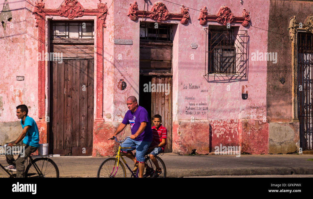 Camaguey, Cuba le 3 janvier 2016 : hommes cubains la bicyclette à travers une rue dans le centre-ville historique de Caraïbes de Camagüey Banque D'Images