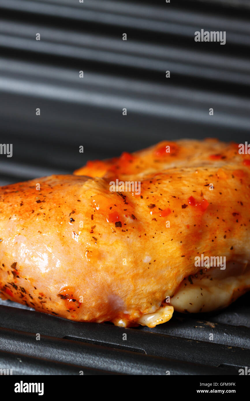 Cuisse de poulet avec la marinade Piri Piri sur un gril électrique Banque D'Images