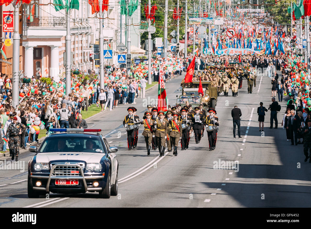La Procession cérémonielle de défilé accompagné par une voiture de police avant-plan. Enginery, militaire et civil sur les fêtes de personnes Banque D'Images