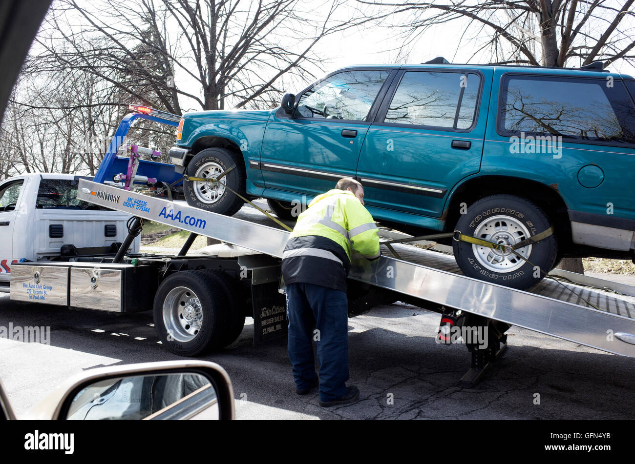 Fixez l'opérateur automobile sur le lit de son camion de remorquage de l'incliné. St Paul Minnesota MN USA Banque D'Images