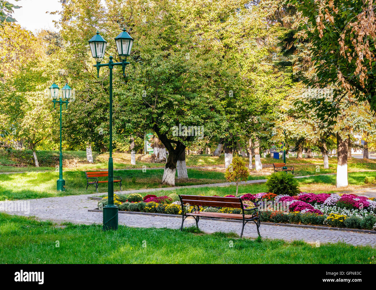 Banc vide près de la lanterne dans le parc de la ville le matin Banque D'Images