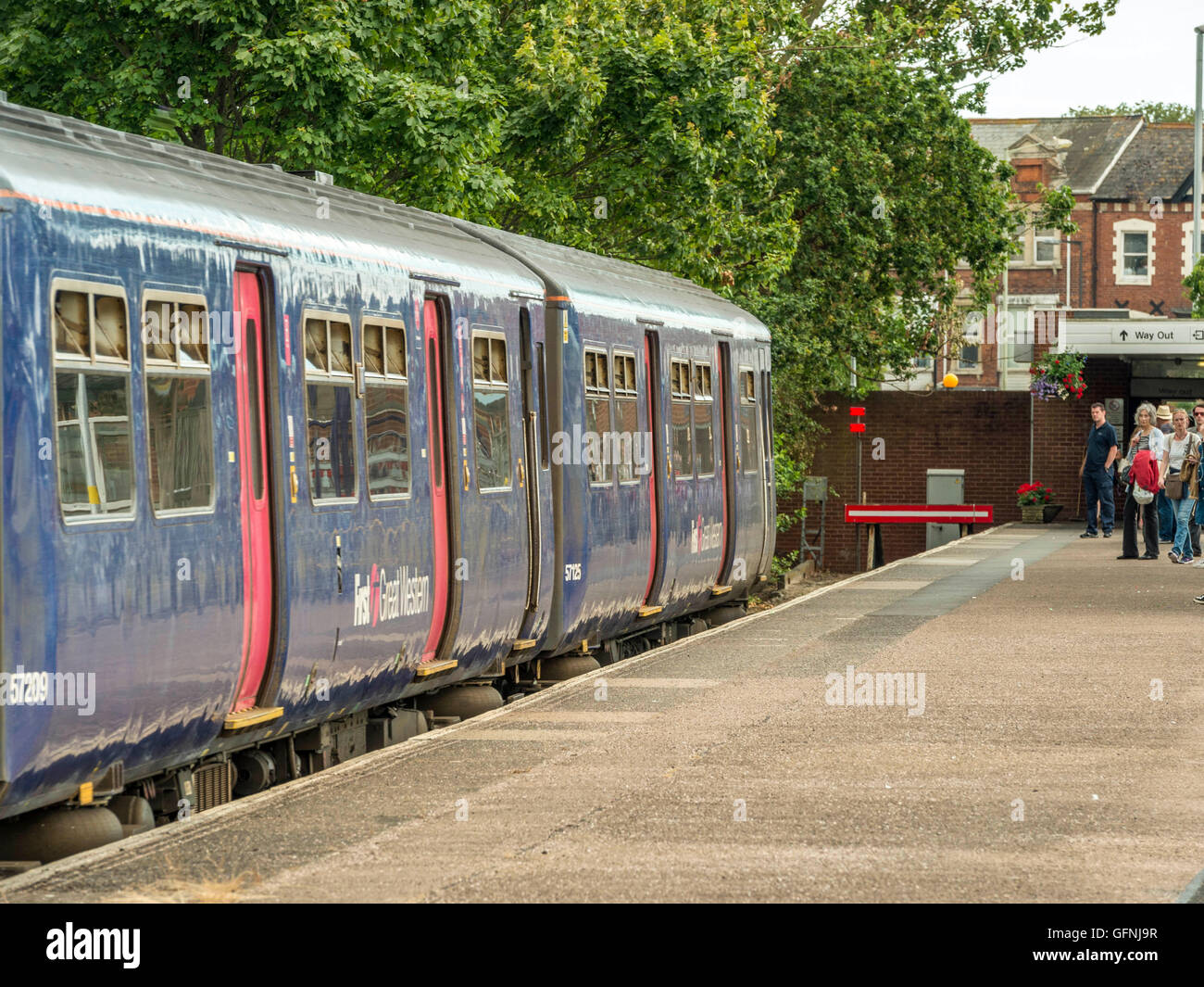 Les passagers se précipitent le long de la plate-forme à bord du Great Western (Bristol) Train arrivant en gare d'Exmouth. Banque D'Images