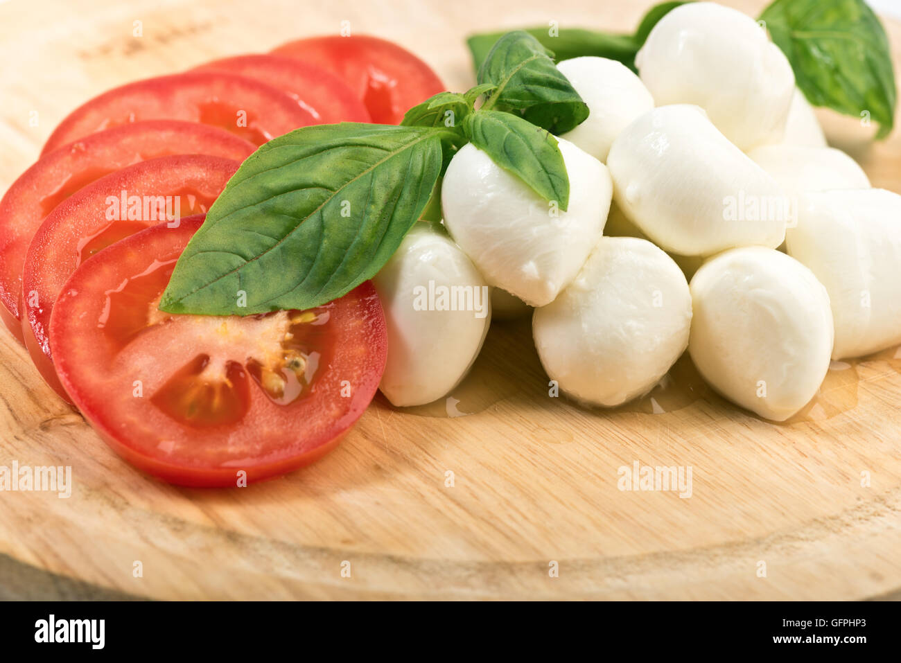 Des tranches de tomate et mozzarella avec des feuilles de basilic Banque D'Images