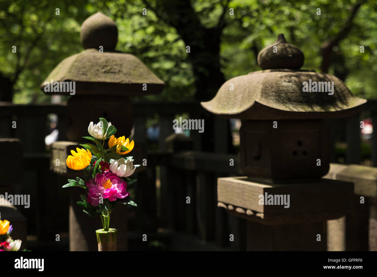 Libre de deux pagodes en pierre et une décoration florale à un petit mémorial d'un prêtre Shinto dans le parc Ueno à Tokyo, Japon Banque D'Images