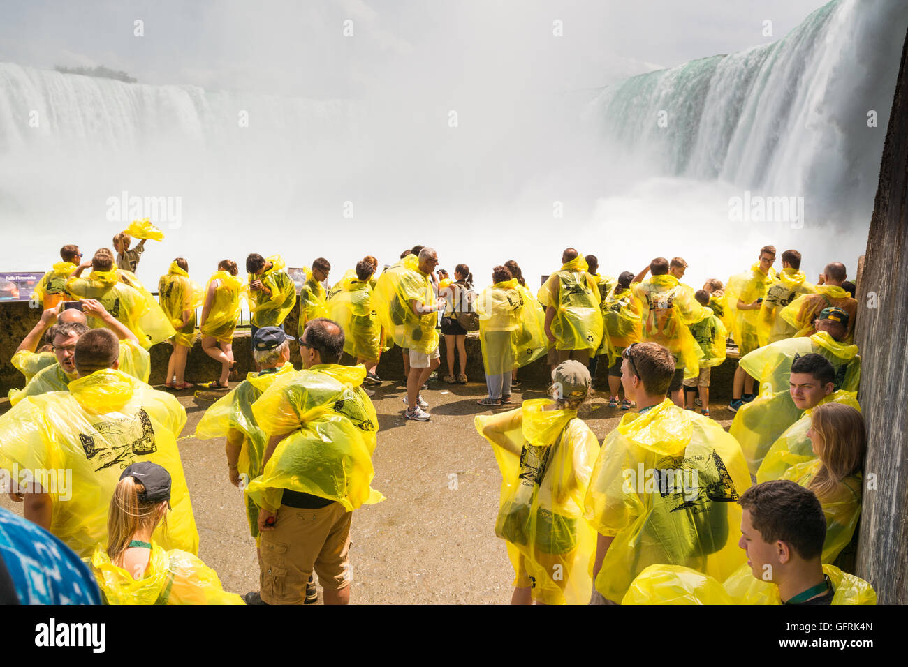 Niagara Falls, Canada - les touristes sur la terrasse d'observation inférieure au pied des chutes les insignes distinctifs de ponchos jaunes Banque D'Images