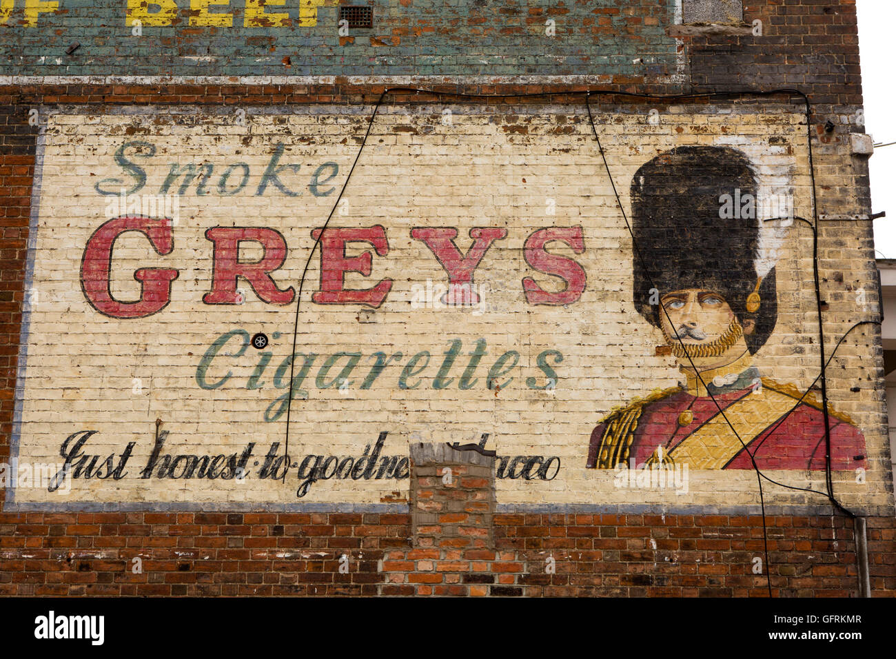 Royaume-uni, Angleterre, Bedfordshire, Bedford, rue de l'Ouest, ancien peint en gris de cigarettes de l'annonce sur mur pignon Banque D'Images