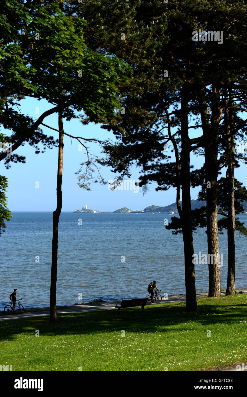 Cycle path Swansea Bay avec pointe emblématique de Mumbles Pier et phare en arrière-plan. Mumbles a été voté meilleur endroit pour vivre au pays de Galles en 2018. Banque D'Images