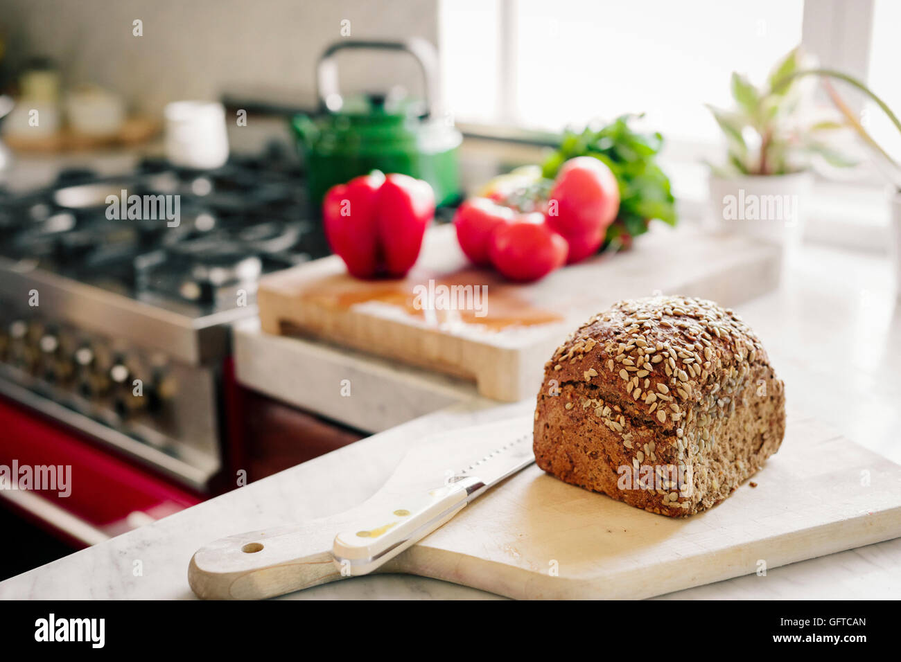 Un pain frais cuit de pain brun sur une carte avec un breadknife Banque D'Images