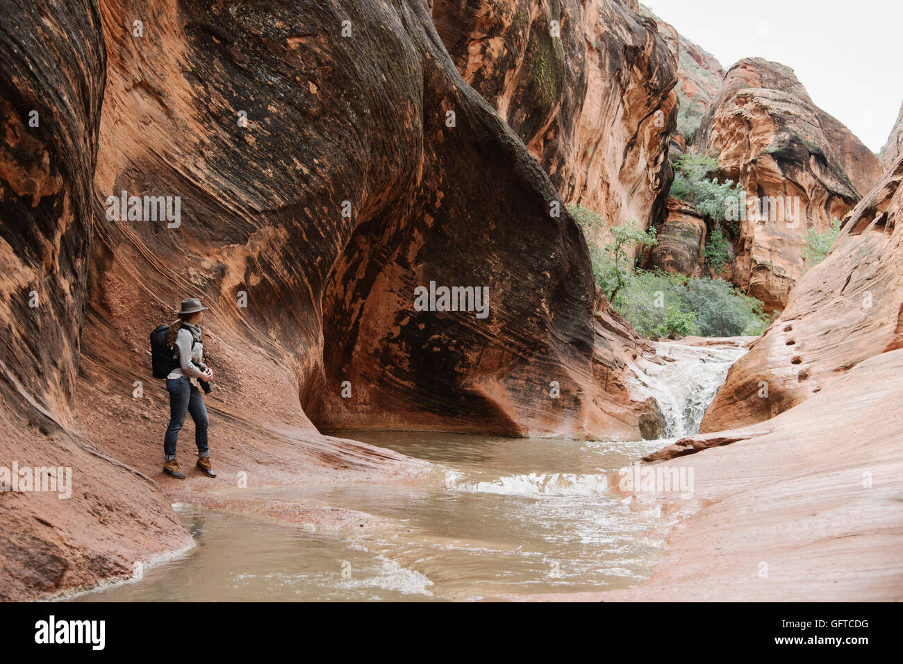 Femme debout par la rivière dans un canyon Banque D'Images