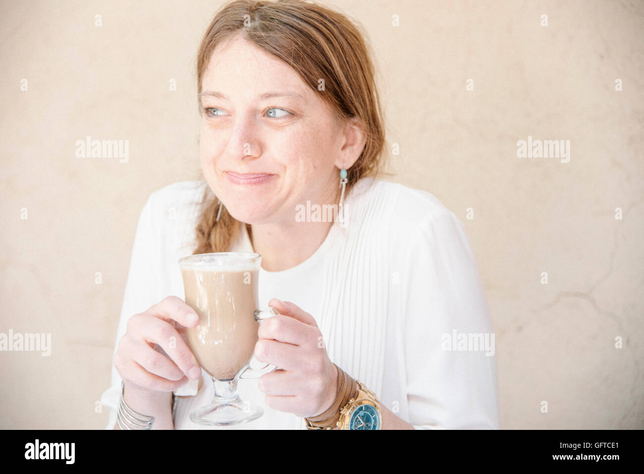 Portrait d'une femme souriante avec des cheveux auburn tiendra un Café Latte Banque D'Images
