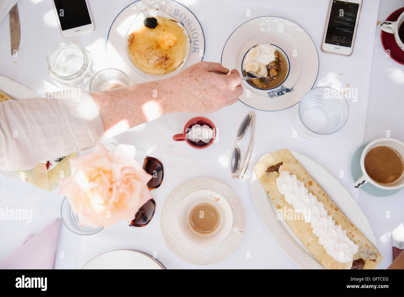 Portrait d'une table avec des aliments et boissons desserts pancake avec crème et tasses de boissons chaudes Banque D'Images
