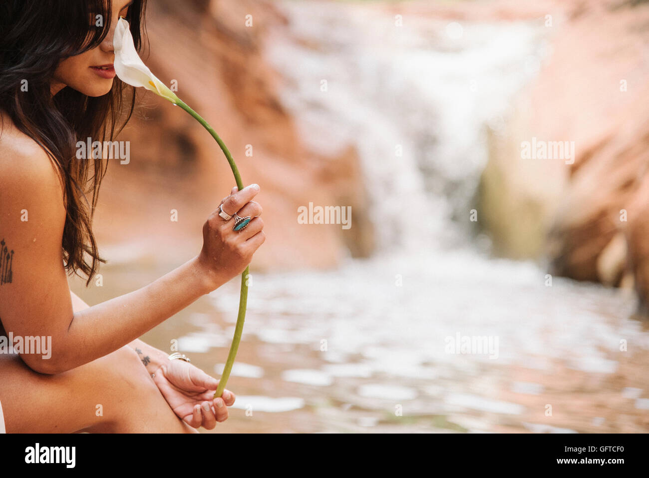 Portrait d'une jeune femme aux longs cheveux bruns assis par une rivière d'Arum une odeur Banque D'Images
