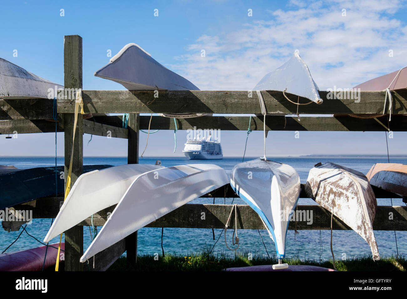 Kayaks inuit traditionnel à l'envers sur une grille avec un paquebot de croisière Océan Mer Sept amarrés Voyager à l'étranger. Nuuk Groenland Banque D'Images