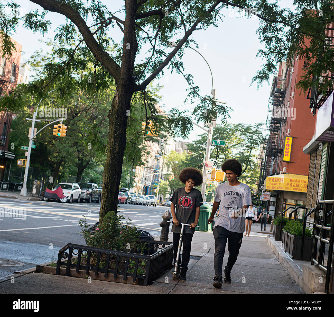 Deux garçons marchant dans la rue dans le quartier de l'East Village de New York. Banque D'Images