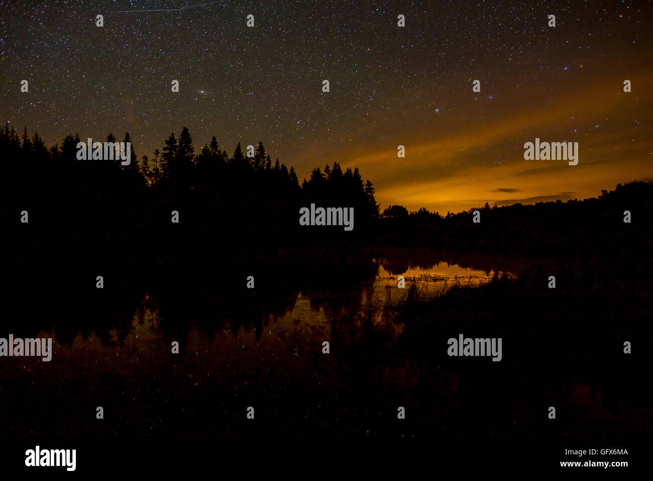 Ciel nocturne reflet dans le lac, Faux-la-Montagne, France Banque D'Images