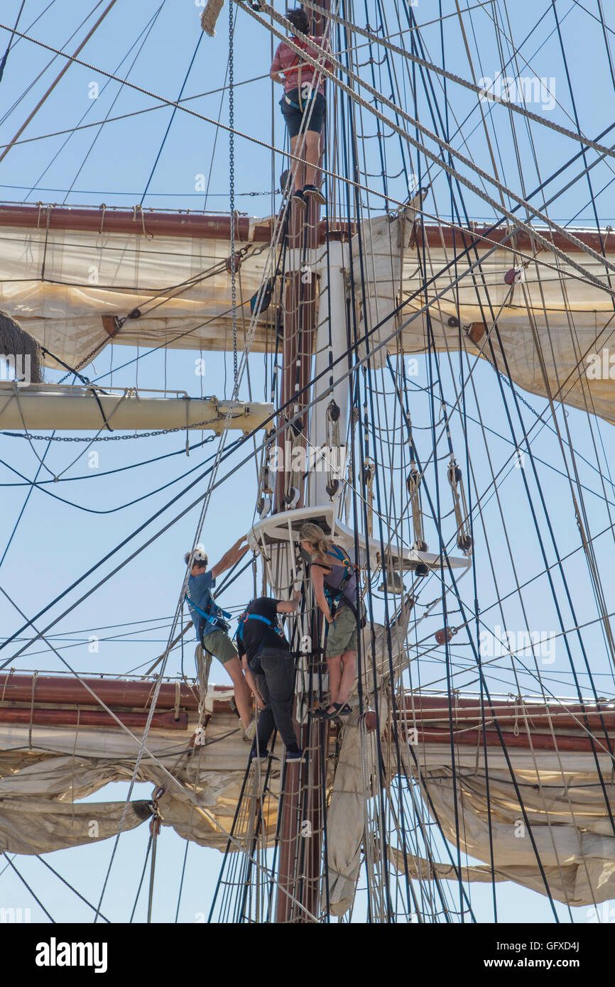 Trois membres de l'équipe travaillant à la préparation de la voile un square rigged ship dock à Lisbonne pendant la course des grands voiliers 2016, Lisbonne Banque D'Images