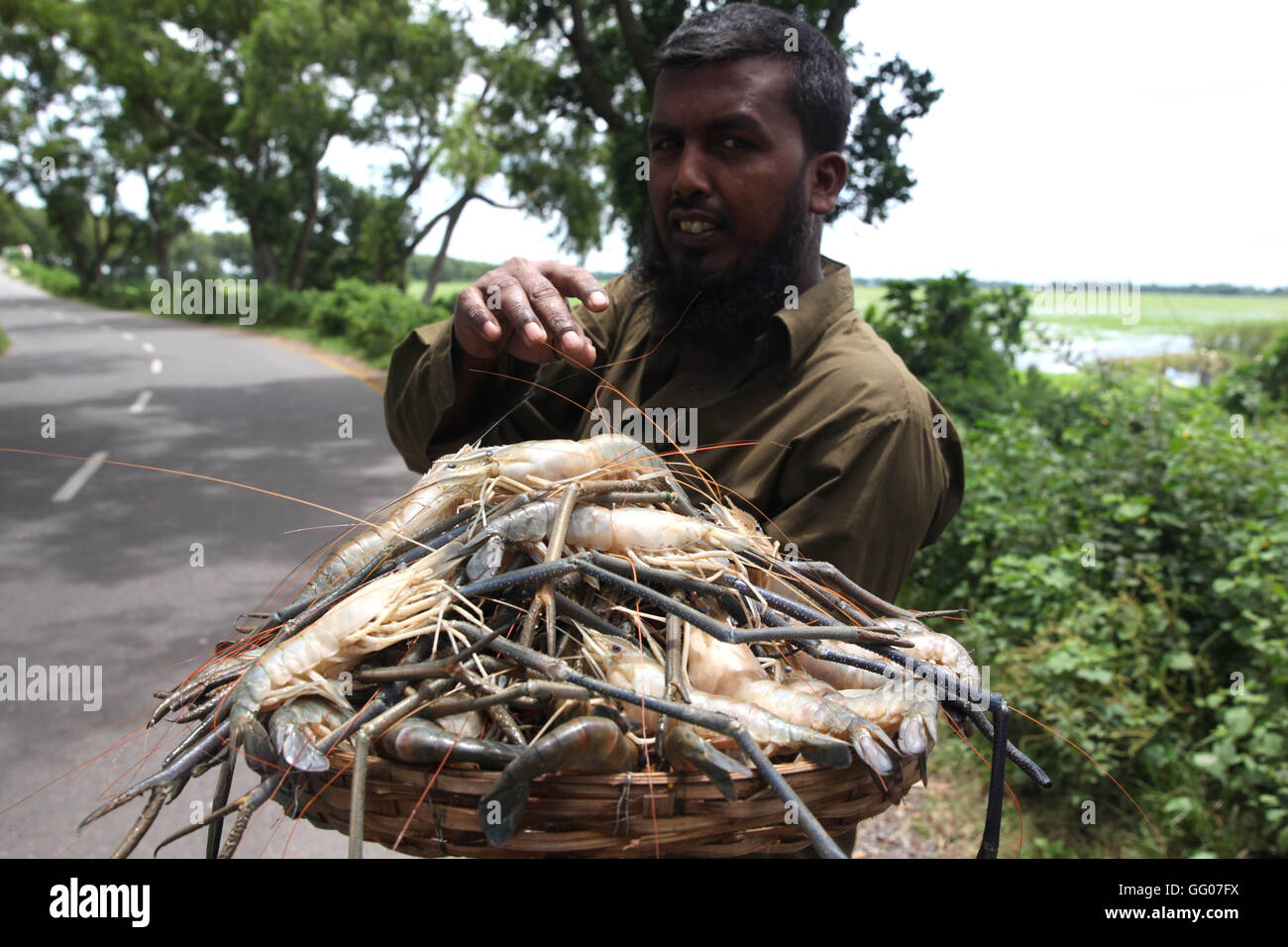 Dhaka, Bangladesh, Nababgonj. 3e août 2016. Un villageois se tenir sur la route pour vendre un pion à l'Dhaka-Dhor road banlieue de Dhaka le 02 août, 2016, Dhaka, Bangladesh. Le poisson est très populaire dans le Bangladesh comme un Banglli amoureux du poisson. Photo : © Monirul Alam Monirul Alam/ZUMA/Alamy Fil Live News Banque D'Images