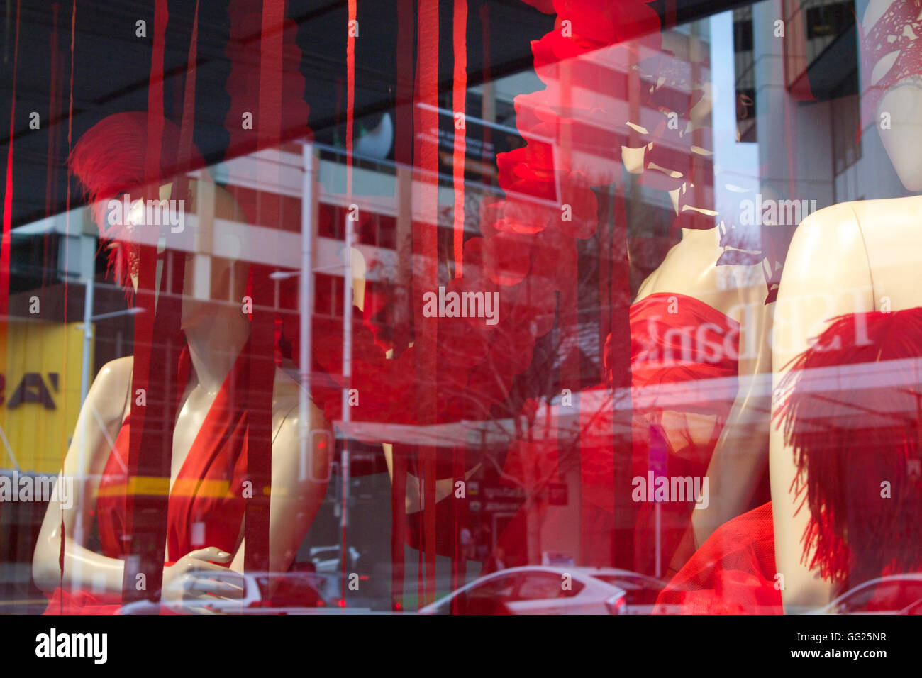 Fenêtre avec store robes rouges Banque D'Images