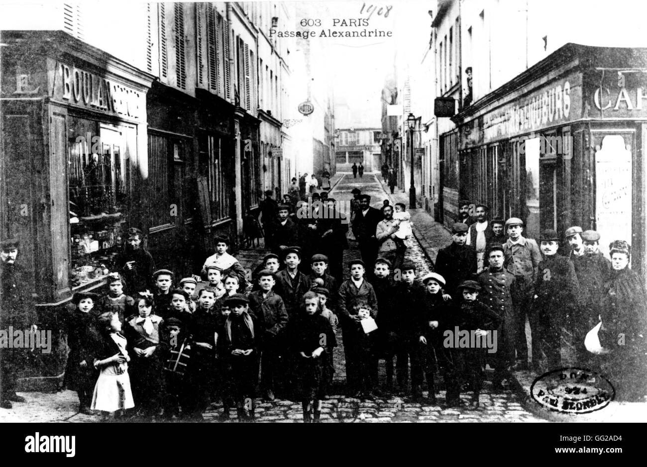 Carte postale d'Alexandrine street à Paris. Les enfants et les adultes posent devant les boutiques 1908 France Banque D'Images