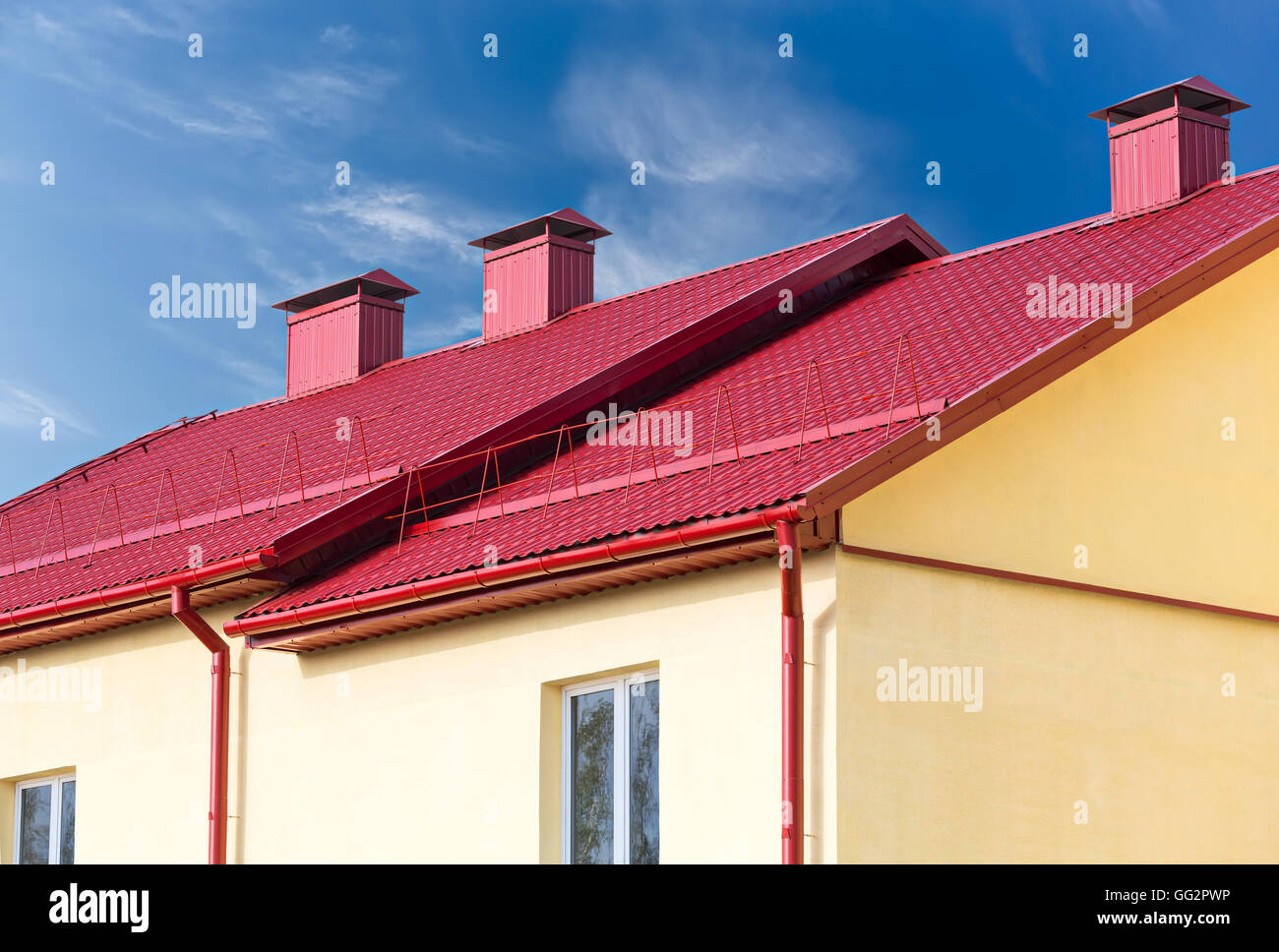 Nouveau toit rouge de la nouvelle chambre avec cheminée contre le ciel bleu Banque D'Images