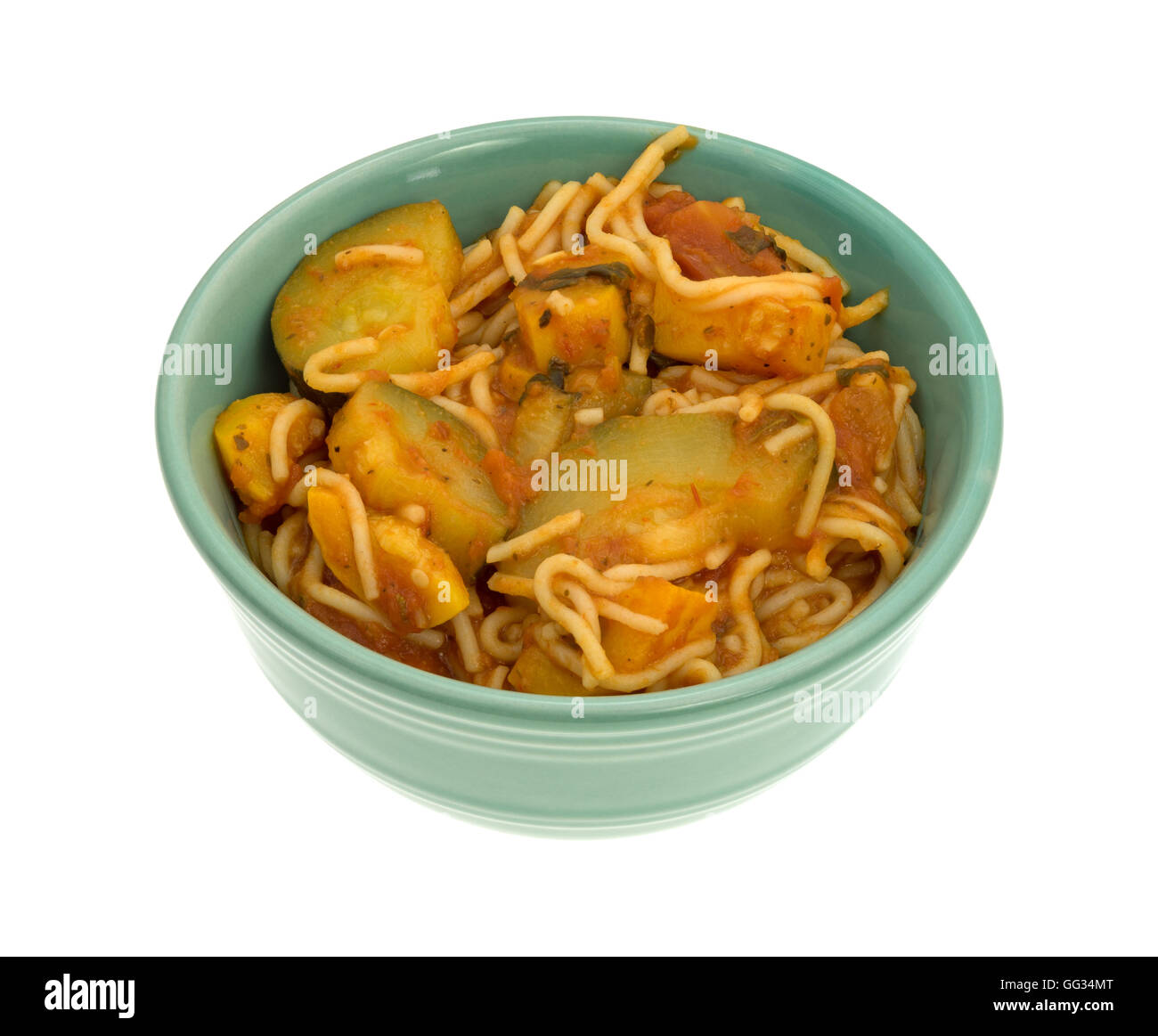 Dîner plat de pâtes cheveux d'ange avec les courgettes et les épinards dans un petit bol vert sur fond blanc. Banque D'Images