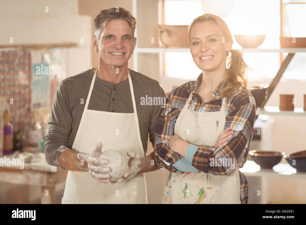 Les potiers souriant debout dans magasin de poterie Banque D'Images