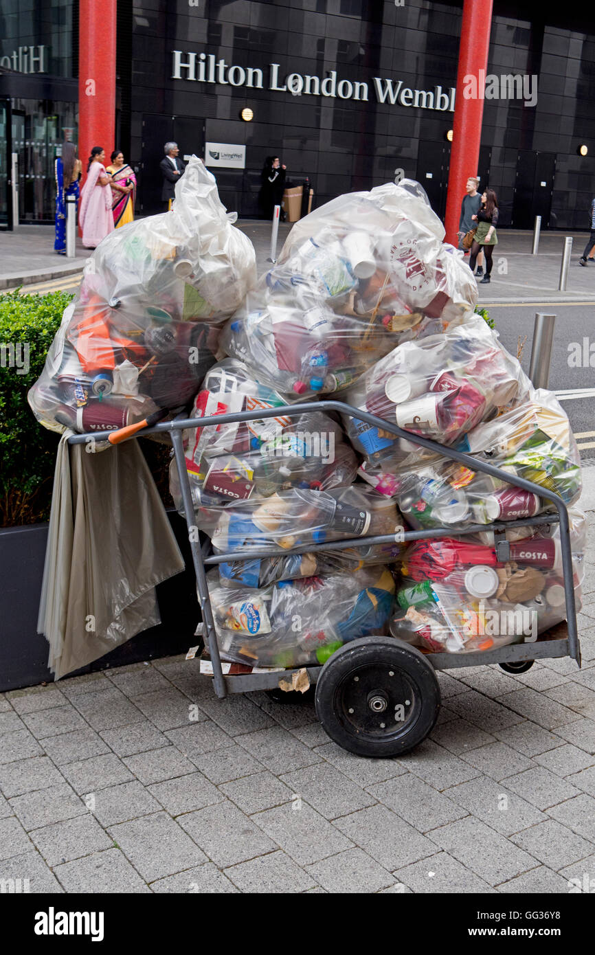 Un chariot plein de sacs poubelle transparent à l'extérieur de l'hôtel Hilton Wembley, l'Angleterre Banque D'Images