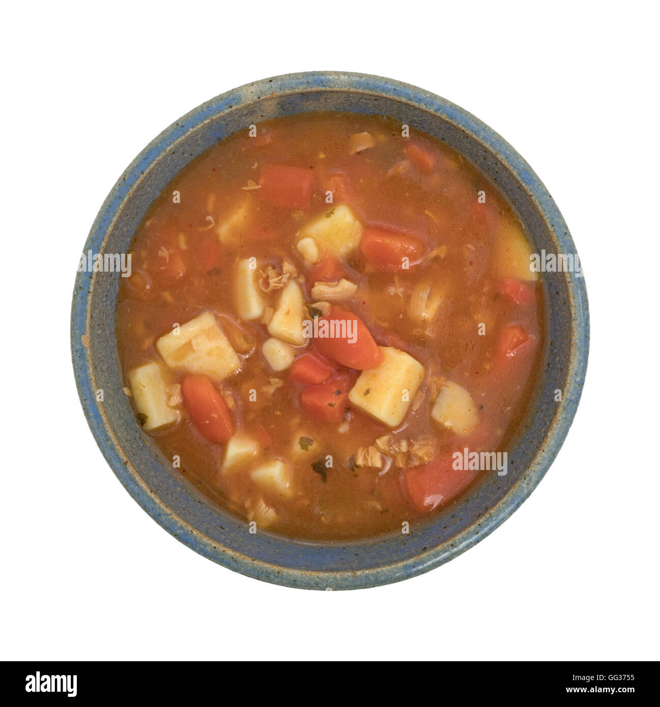 Vue de dessus d'une portion de style manhattan clam chowder dans un vieux bol en grès sur un fond blanc. Banque D'Images