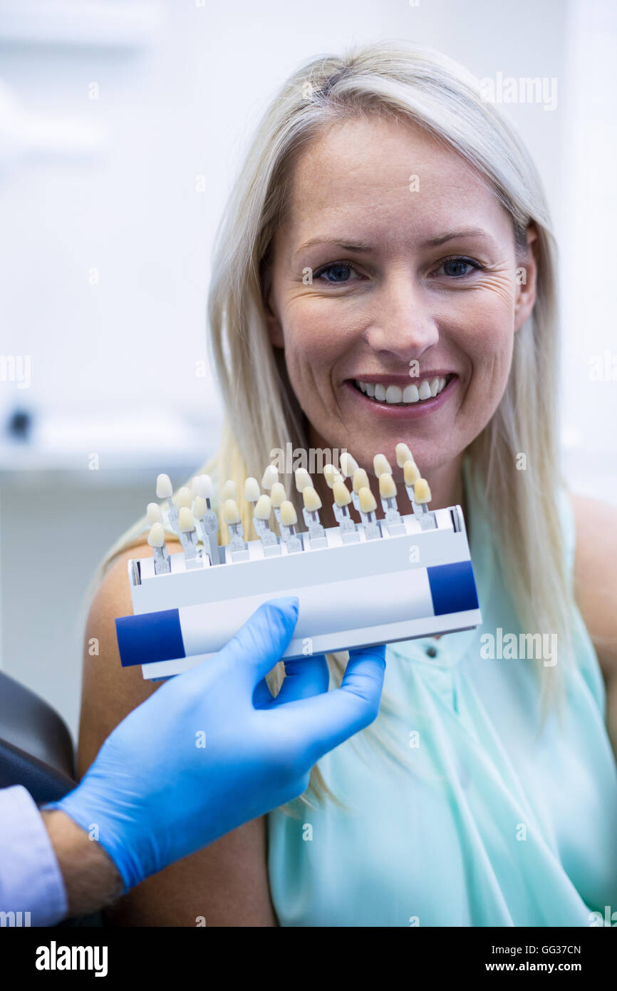 Dentiste dents tout en nuances holding smiling female patient Banque D'Images