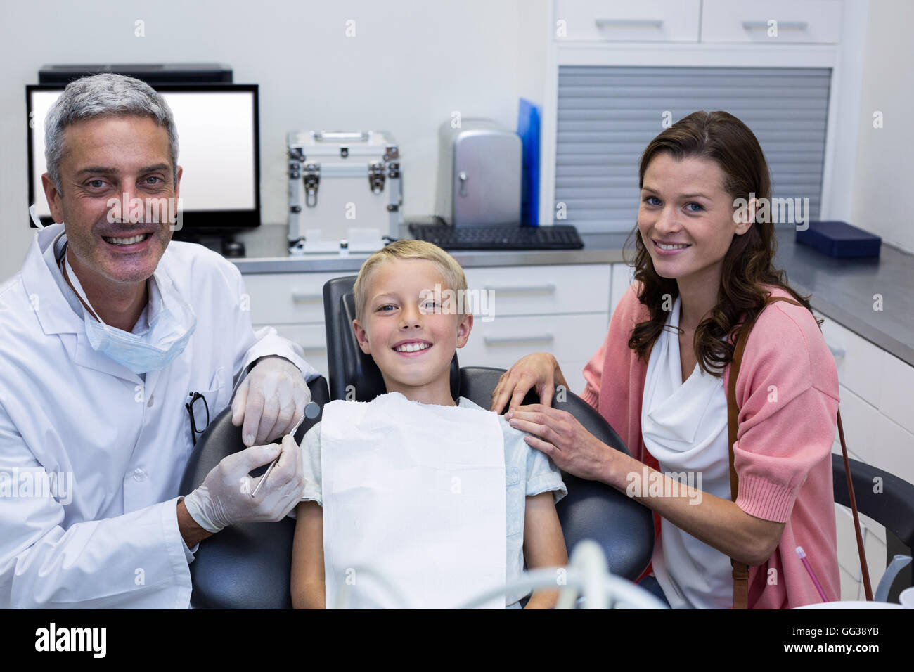 Portrait de dentiste avec jeune patient et sa mère Banque D'Images