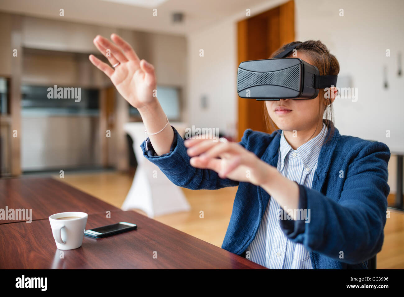 Jeune femme à l'aide de lunettes de réalité virtuelle Banque D'Images