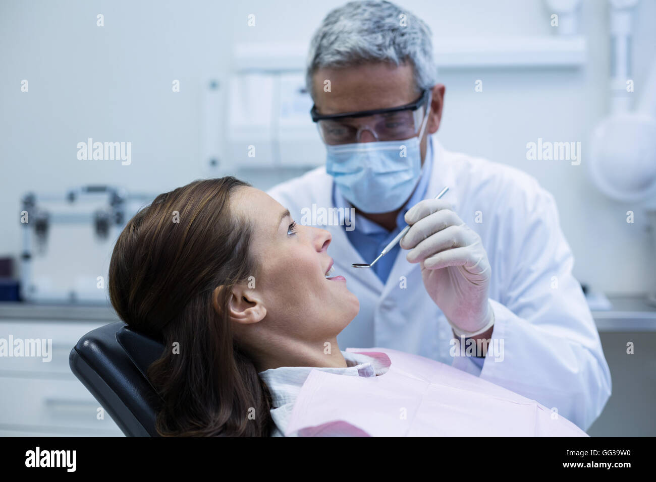 Dentiste de l'examen d'un jeune patient à l'aide d'outils Banque D'Images