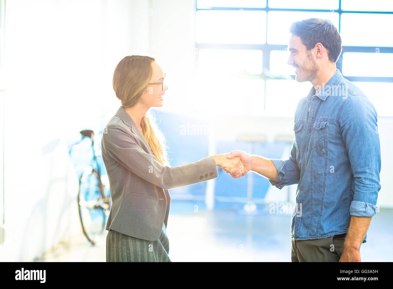 Businesswoman shaking hands with coworker Banque D'Images
