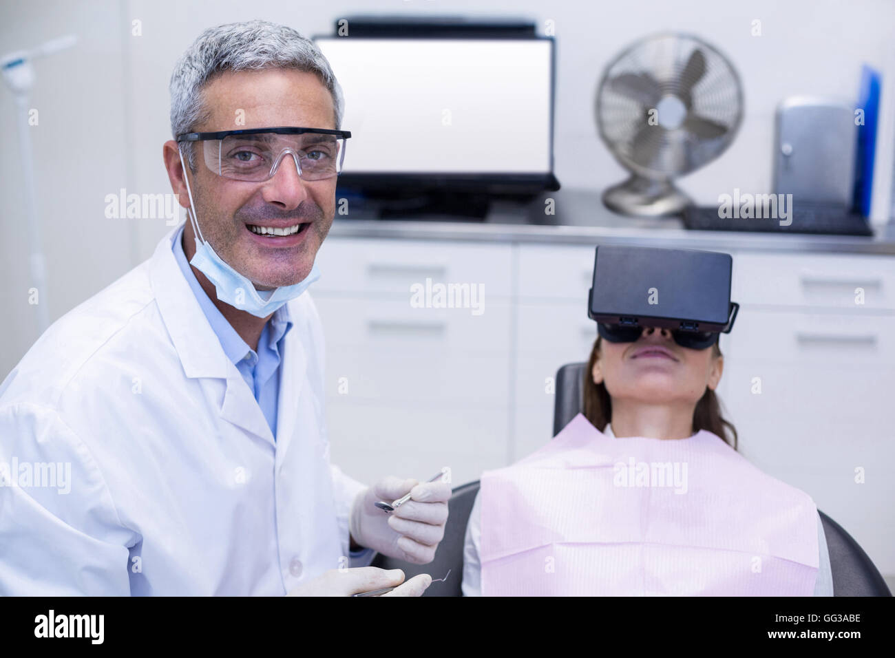 Femme de casque de réalité virtuelle lors d'une visite dentaire Banque D'Images