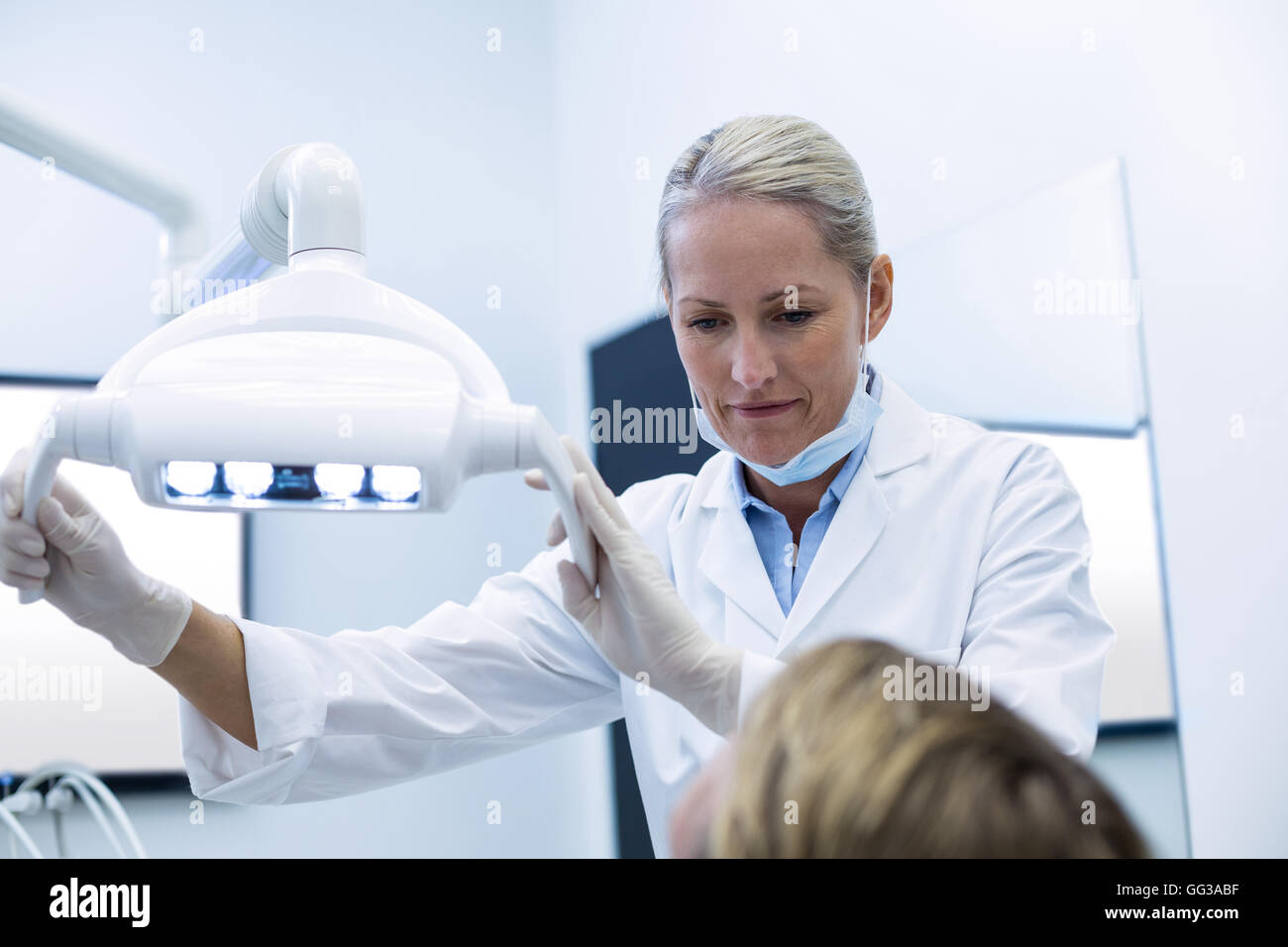 Réglage de l'éclairage dentaire dentiste femelle Banque D'Images