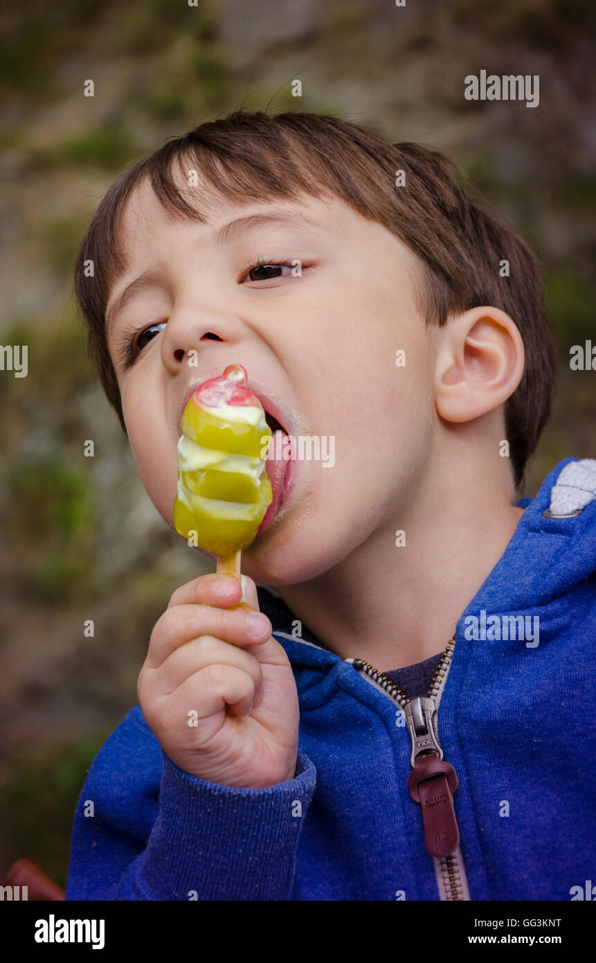 Un jeune garçon mange une glace lolly Banque D'Images