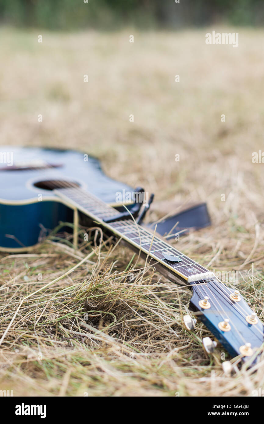 Guitare acoustique en bois bleu lying on grass Banque D'Images