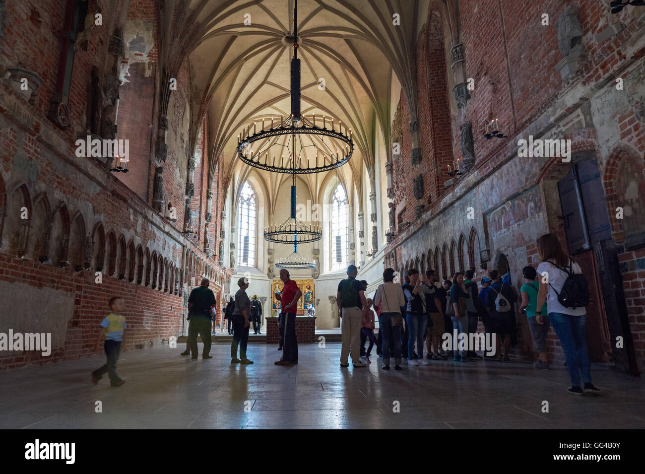 Les touristes visitant la Bienheureuse Vierge Marie dans l'église du château de l'Ordre Teutonique de Malbork, Pologne Banque D'Images