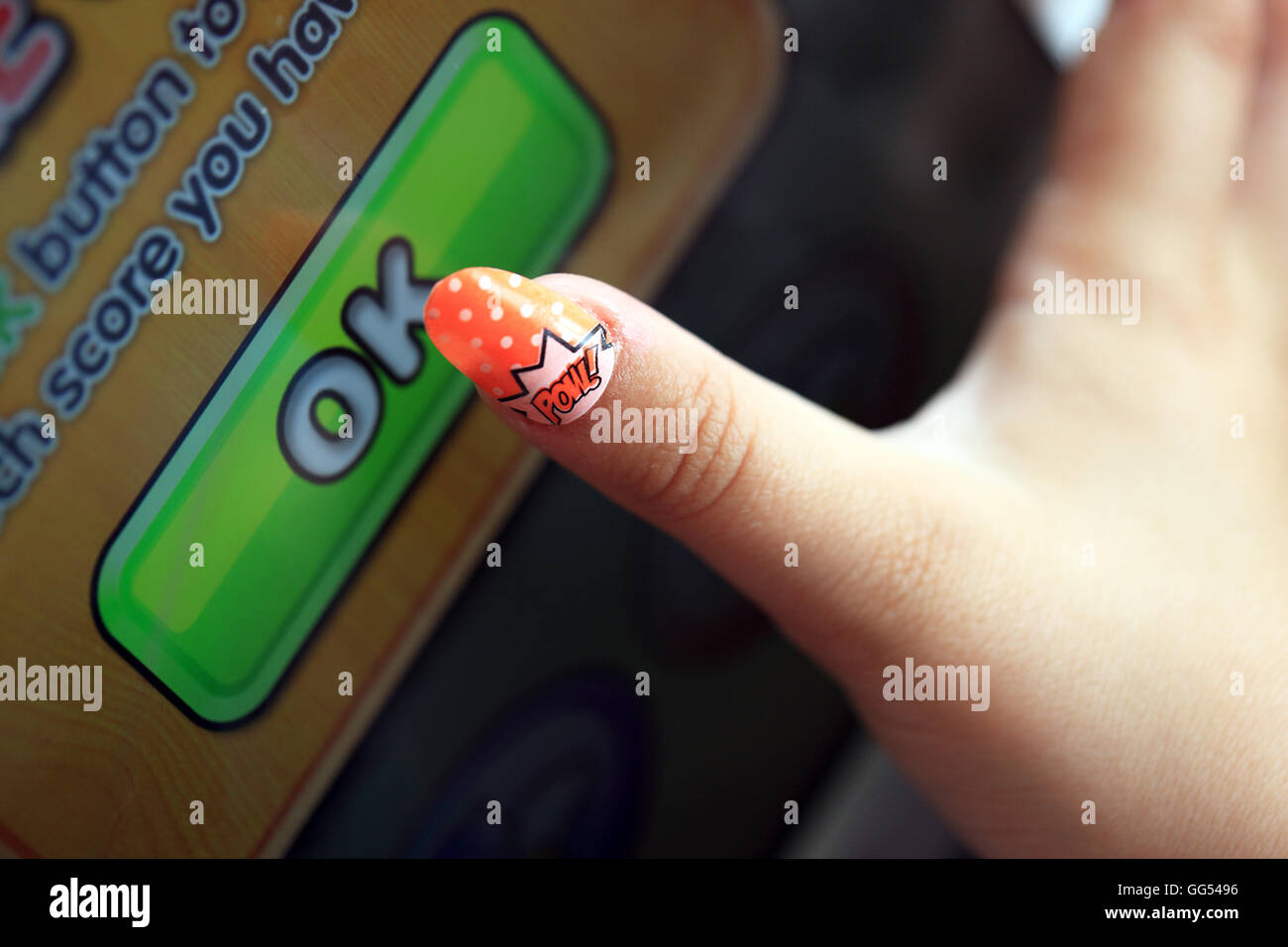 Sept ans filles doigt frappant OK sur une app Banque D'Images