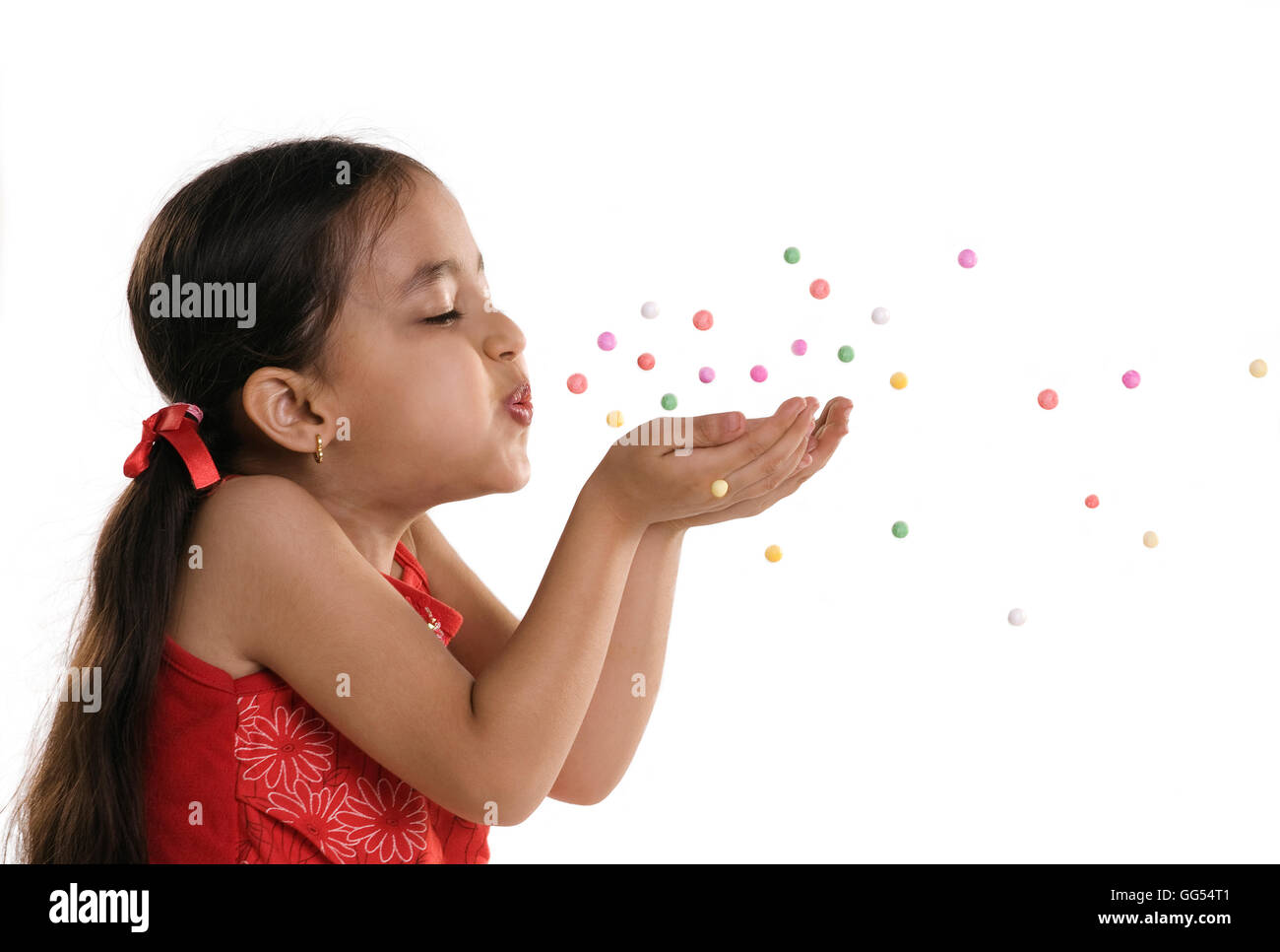 A little girl blowing confetti Banque D'Images