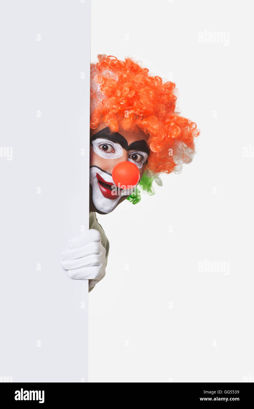 Happy Clown cache derrière billboard sur fond blanc Banque D'Images
