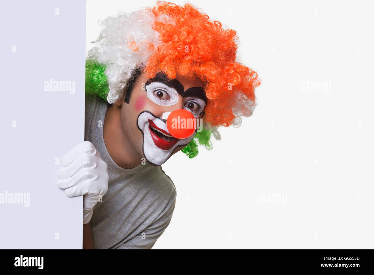 Perruque tricolore en clown mâle smiling over white background Banque D'Images